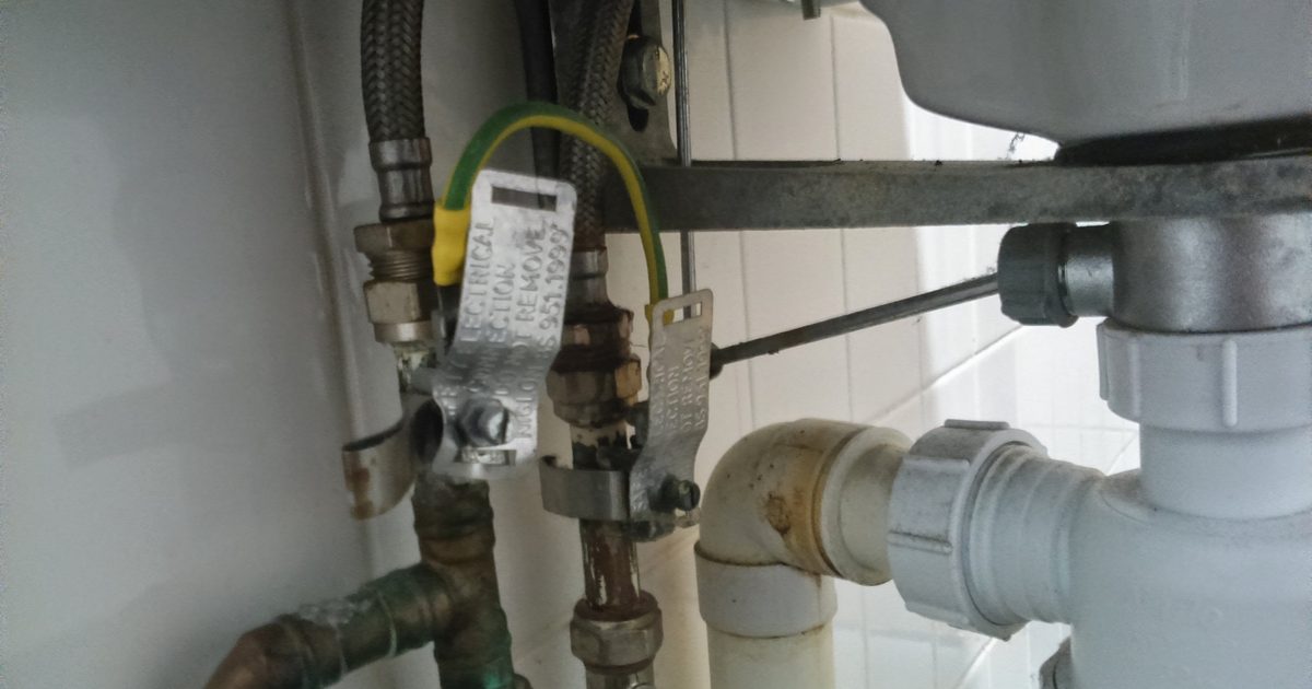 Close-up of under-sink plumbing and drain pipe fittings