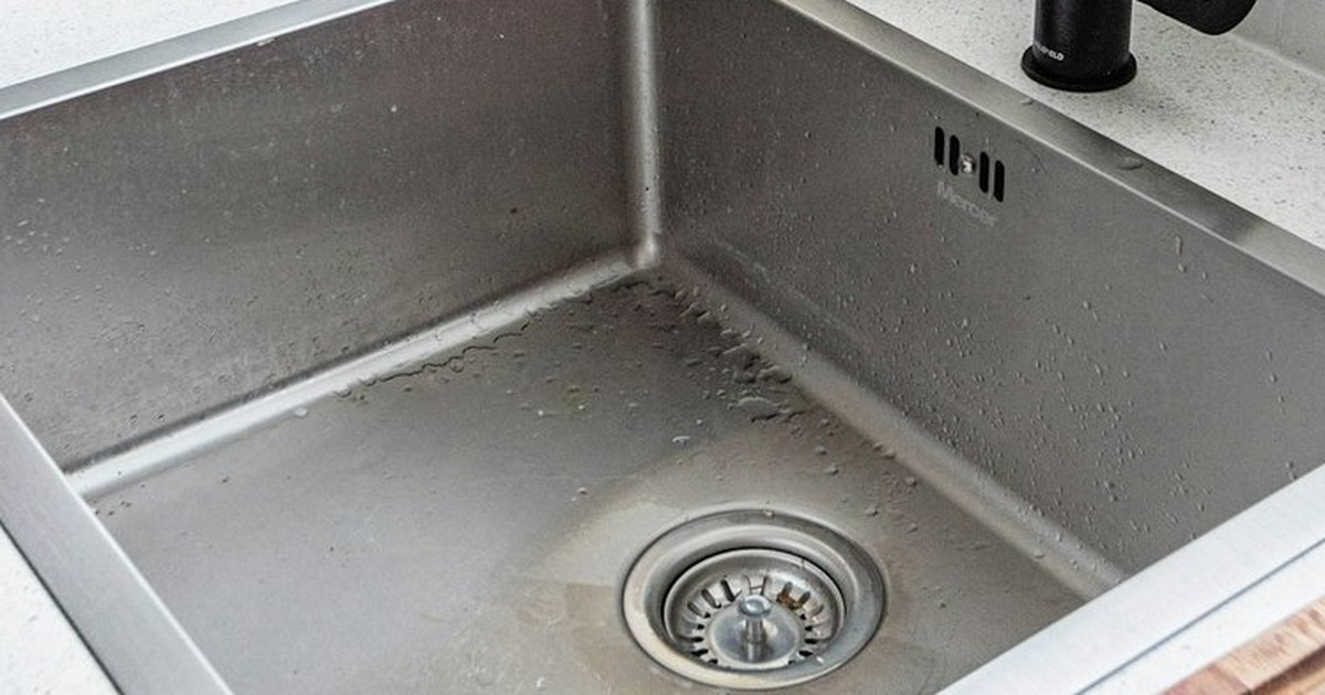 Stainless steel kitchen sink with a chrome drain fitting and plug hole