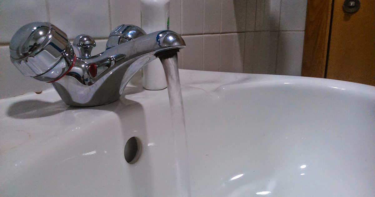 Bathroom mixer tap running water into a basin