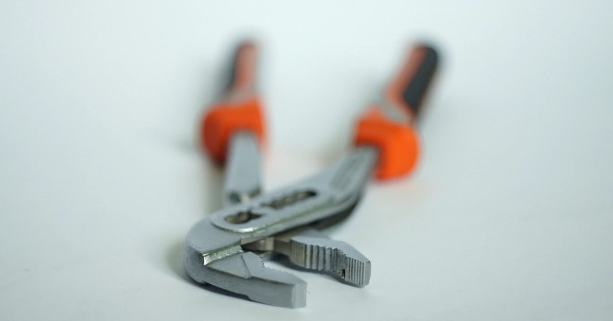 Adjustable plumbing pliers on a light surface