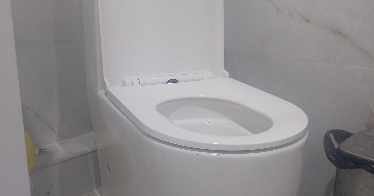 A white toilet in a tiled bathroom