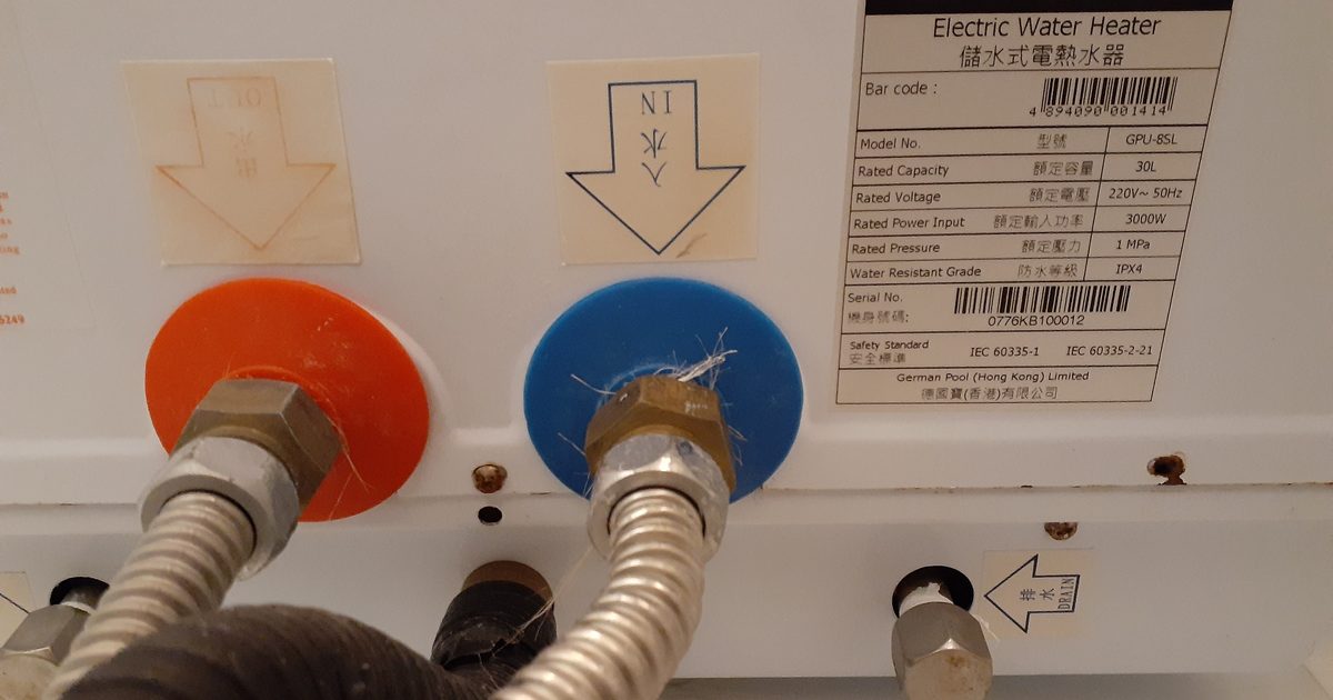 Close-up of hot and cold connections on an electric hot water heater